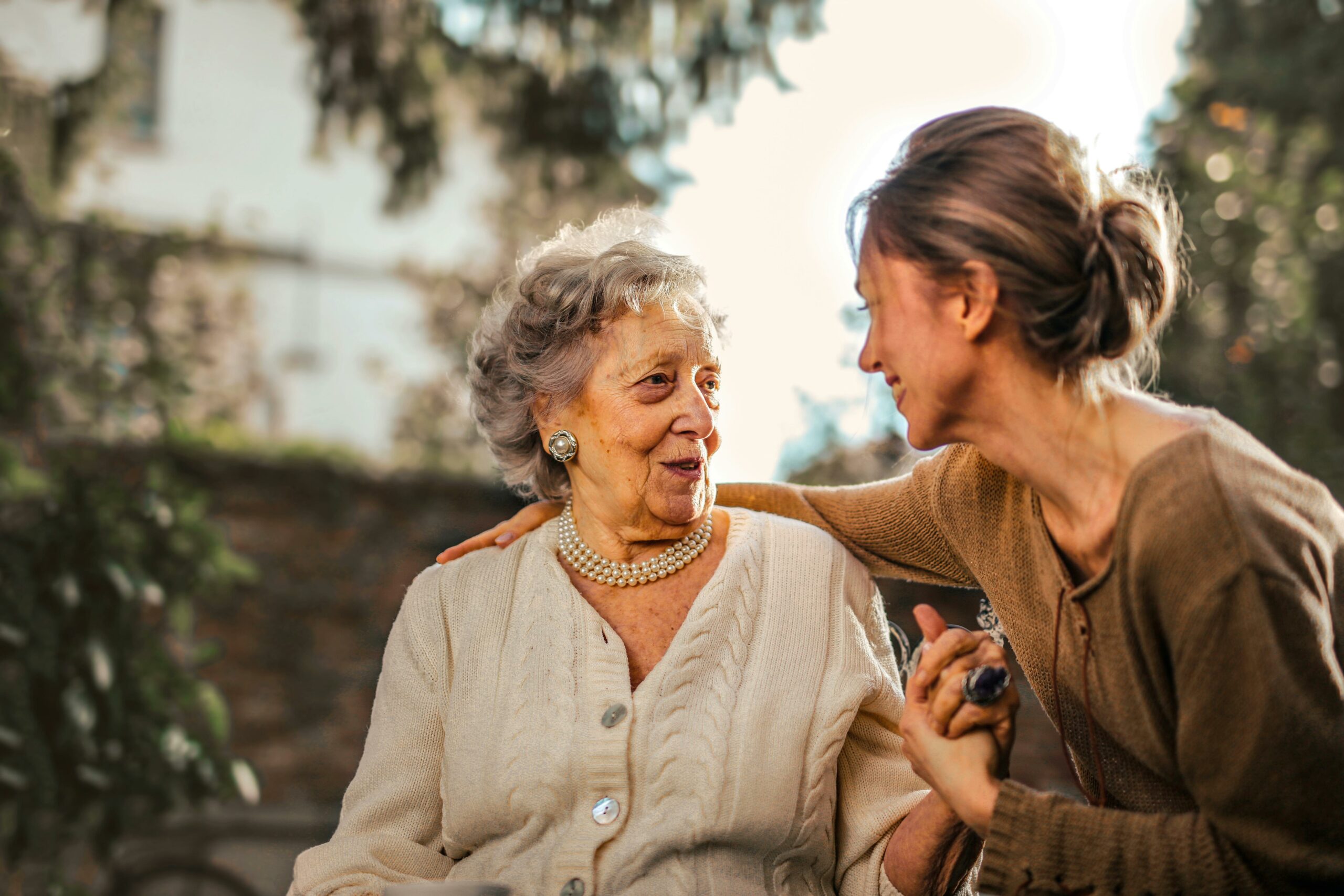 A young woman puts an arm around an older woman.